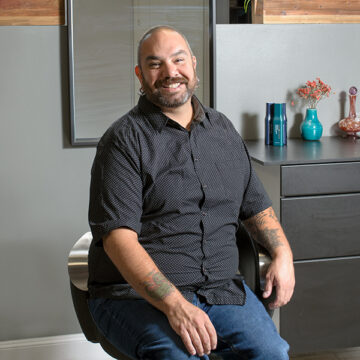 Portrait of Locke Hair stylist Stephen, smiling and sitting comfortably in a salon chair