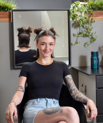 Portrait of Locke stylist Tori, smiling, in the salon environ